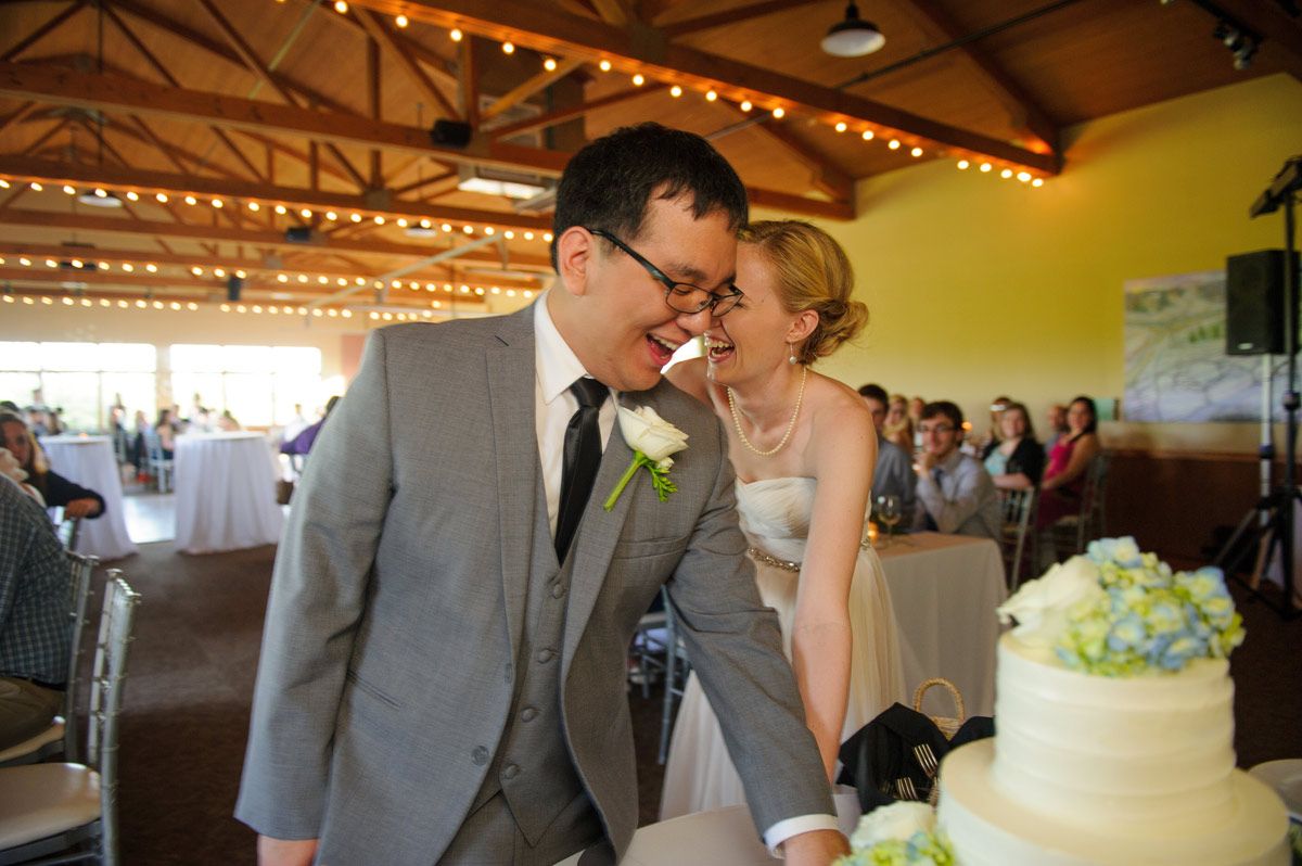 Bride and groom having fun while cutting the cake